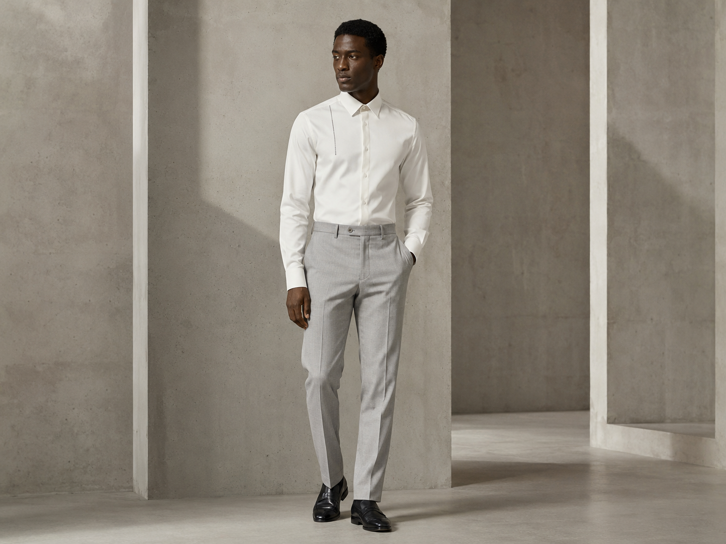 Model wearing a white STRUCTURE shirt with clean light-grey trousers.